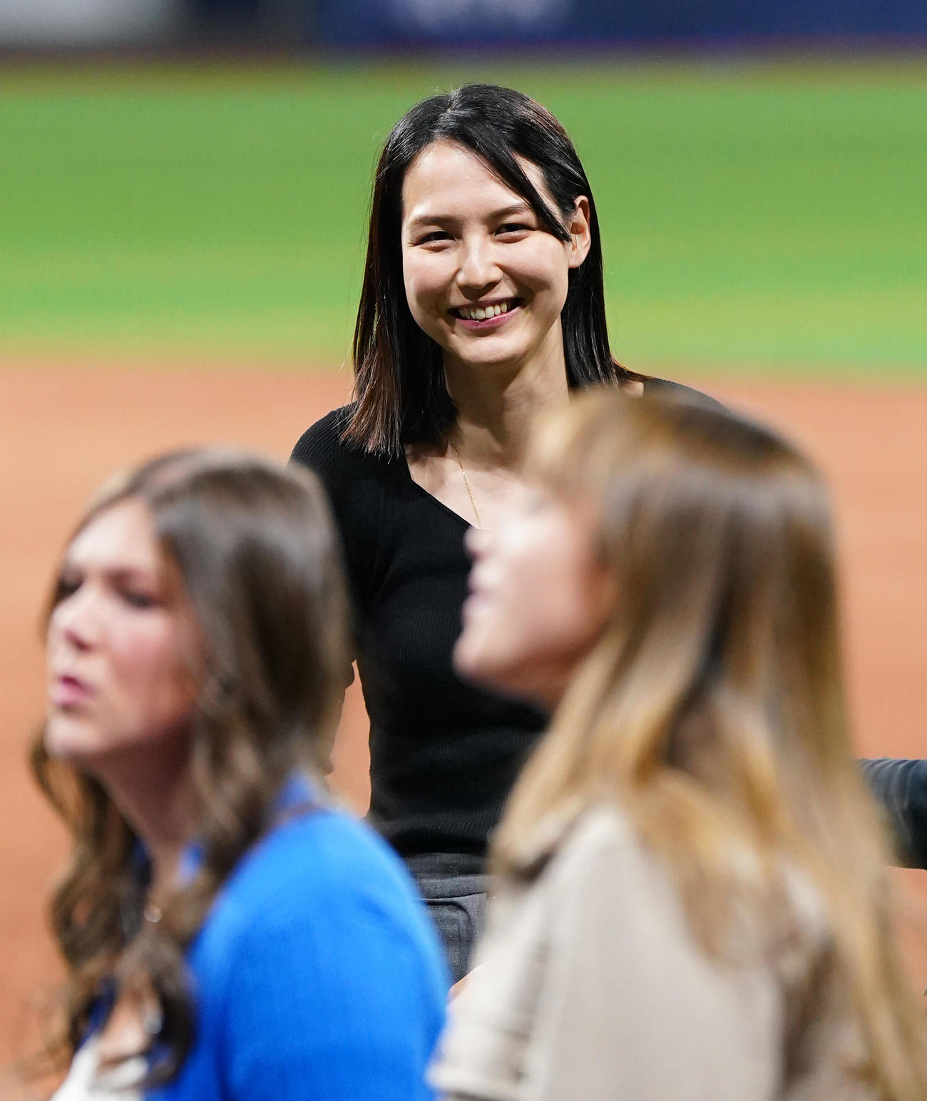ドジャース対パドレス　試合後にフィールドで関係者と笑顔で話す真美子夫人（撮影・菅敏）