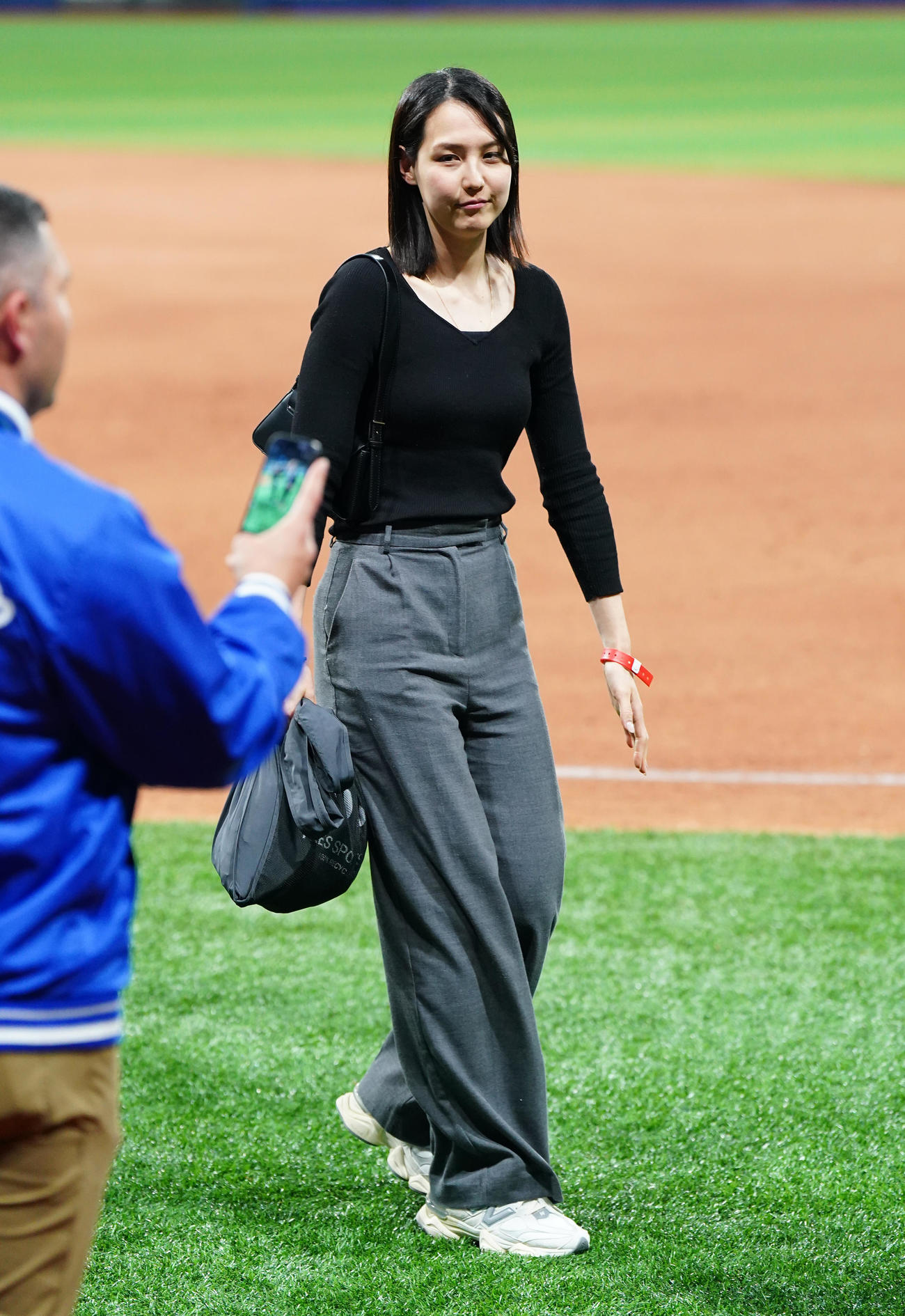 ドジャース対パドレス　試合後にフィールドで関係者と笑顔で話す真美子夫人（左）（撮影・菅敏）
