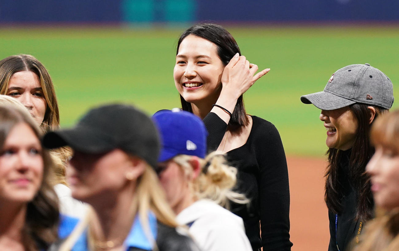 ドジャース対パドレス　試合後にフィールドで関係者と笑顔で話す真美子夫人（中央）（撮影・菅敏）