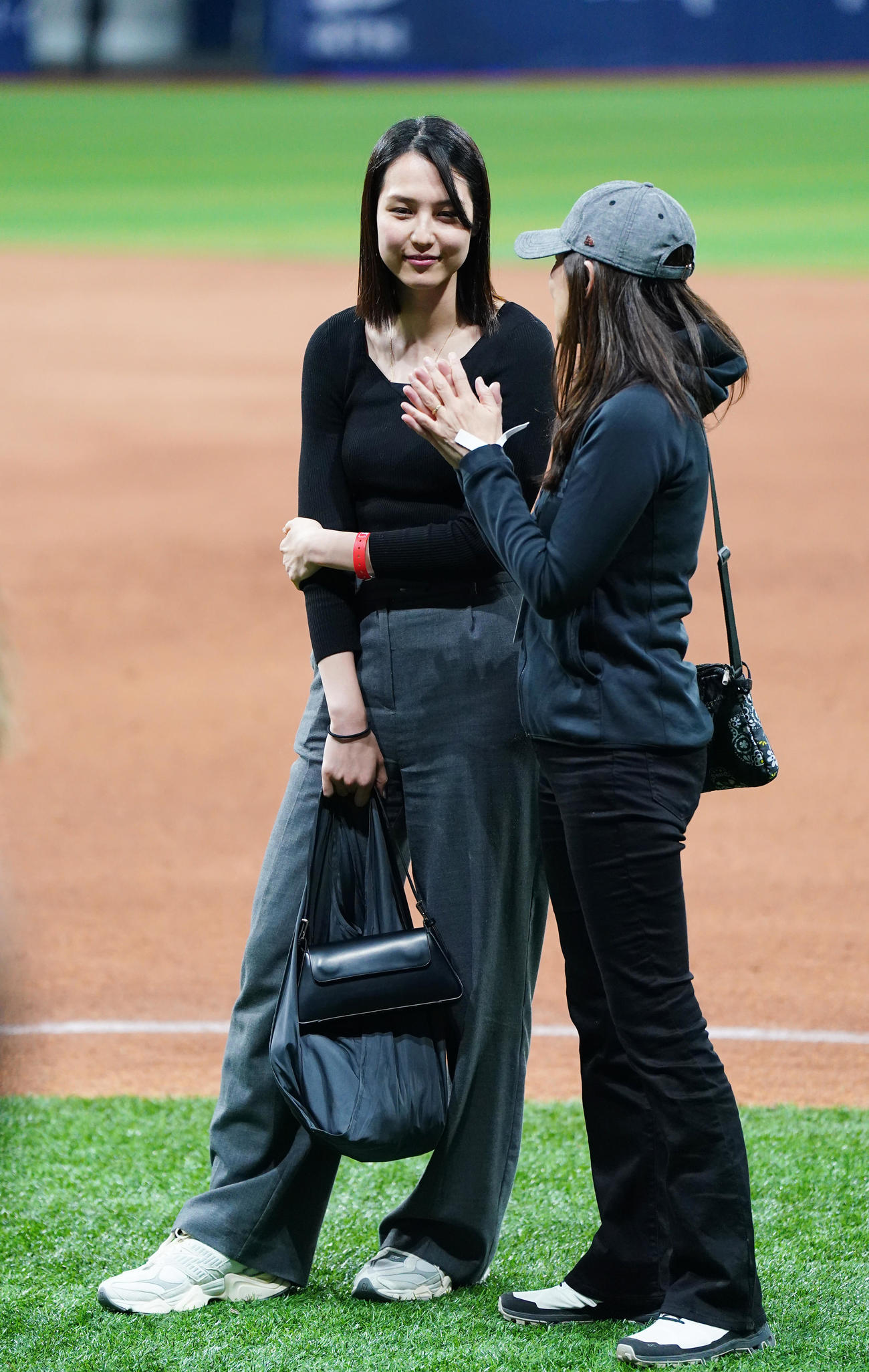 ドジャース対パドレス　試合後にフィールドで関係者と話す真美子夫人（左）（撮影・菅敏）