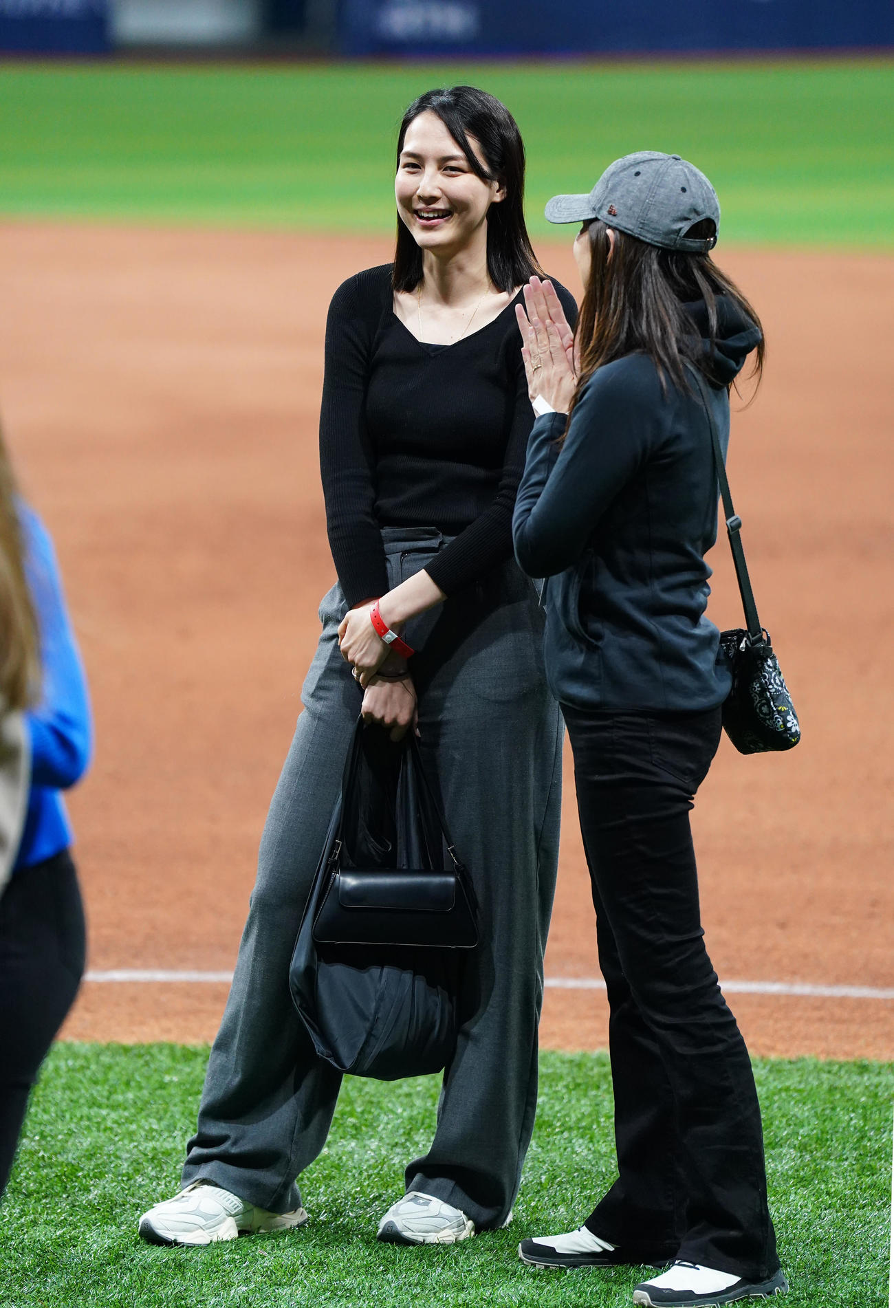 ドジャース対パドレス　試合後にフィールドで関係者と話す真美子夫人（左）（撮影・菅敏）