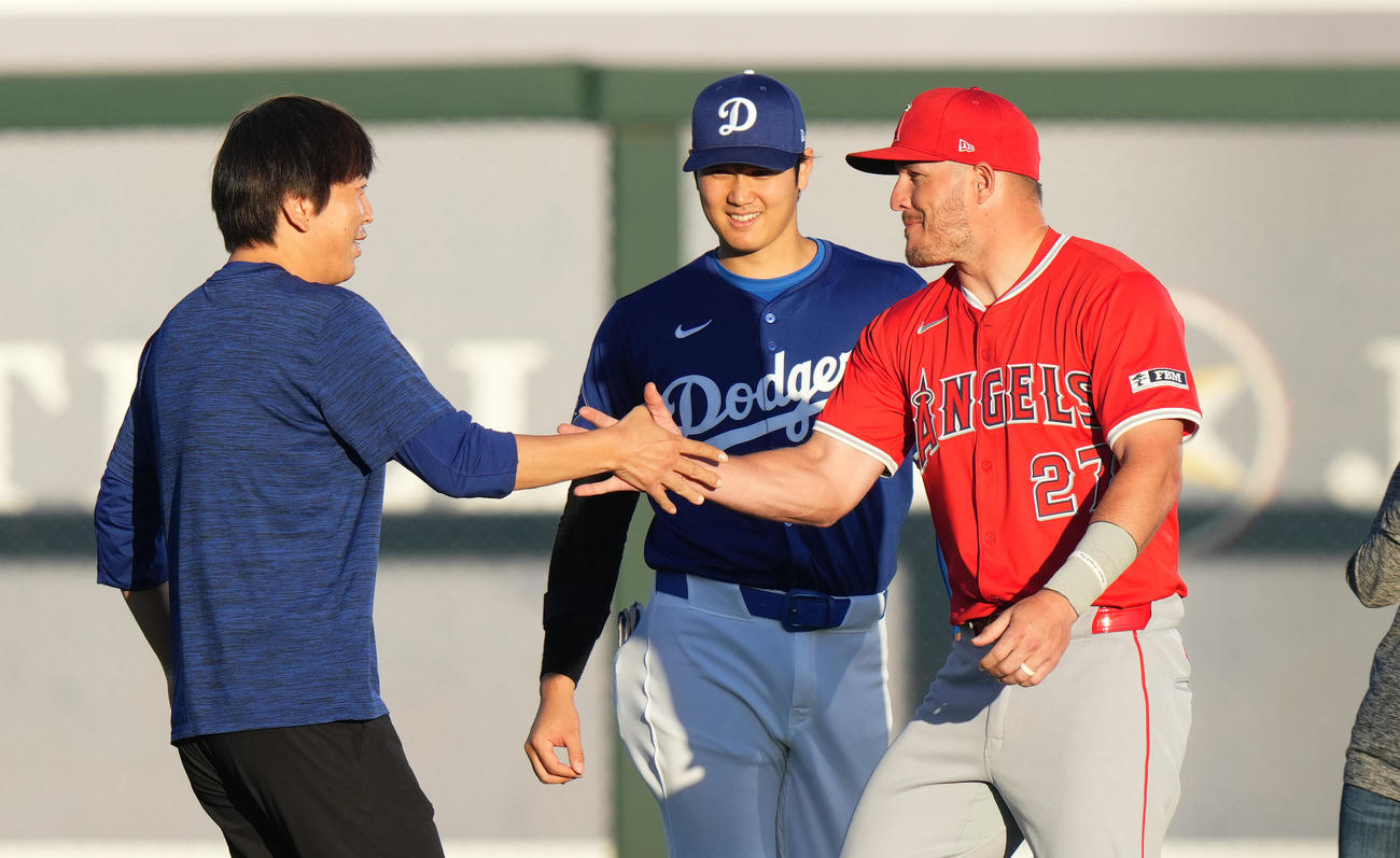3月5日、エンゼルス・トラウト（右）に握手であいさつする水原通訳。中央は大谷