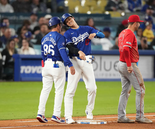 ドジャース対エンゼルス　5回裏ドジャース2死、四球を選び、一塁走塁コーチとヘルメットでタッチをする大谷（中央）（撮影・菅敏）
