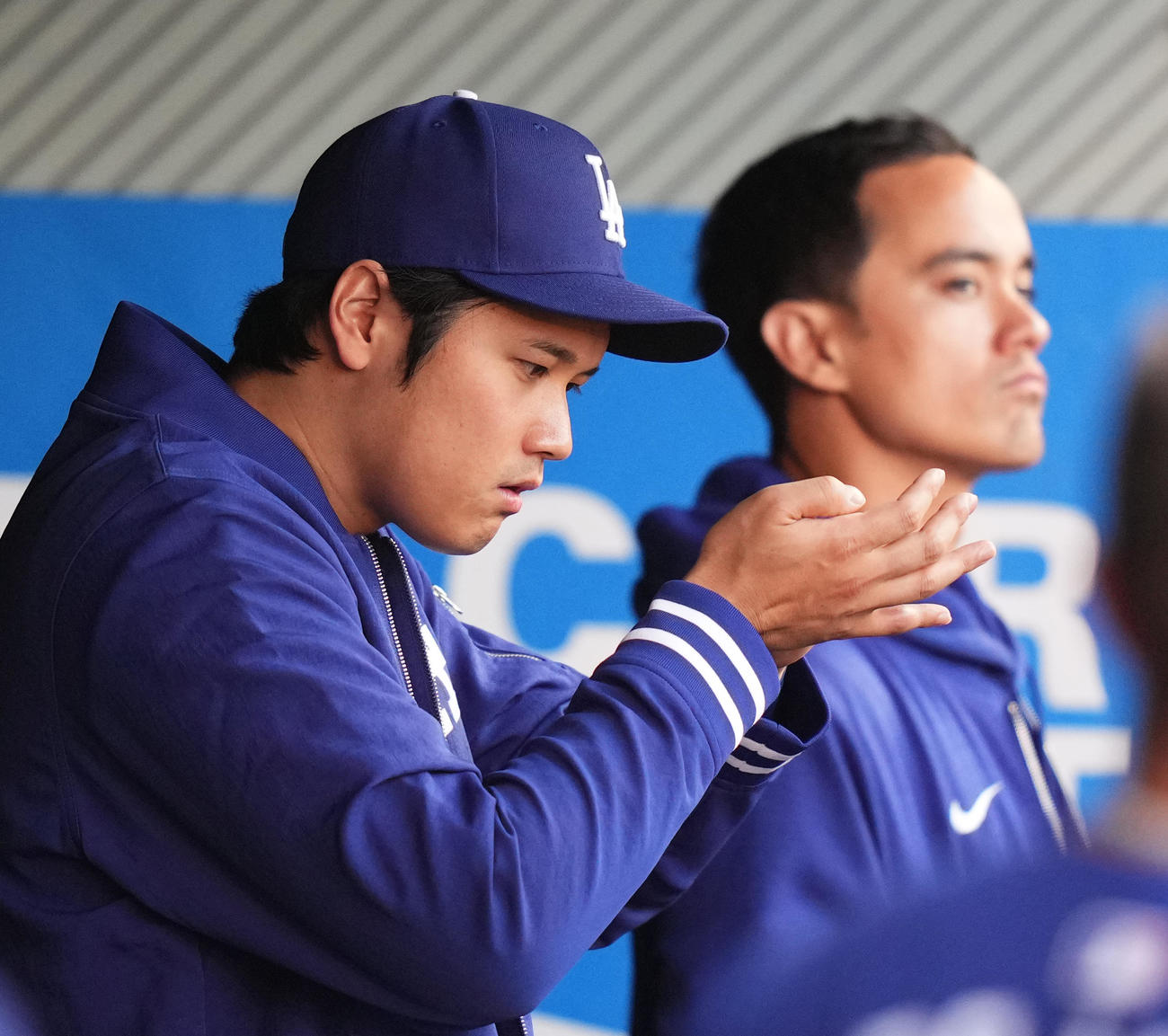 エンゼルス対ドジャース　ベンチで指を見つめるドジャース大谷。後方はアイアトン通訳（撮影・菅敏）