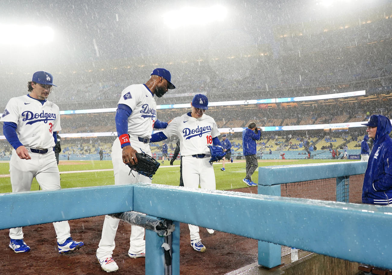 ドジャース対カージナルス　5回を前にフィールドに出るも雨が強くなり、笑顔でヘイワード（中央)とベンチに戻るドジャース山本（撮影・菅敏）