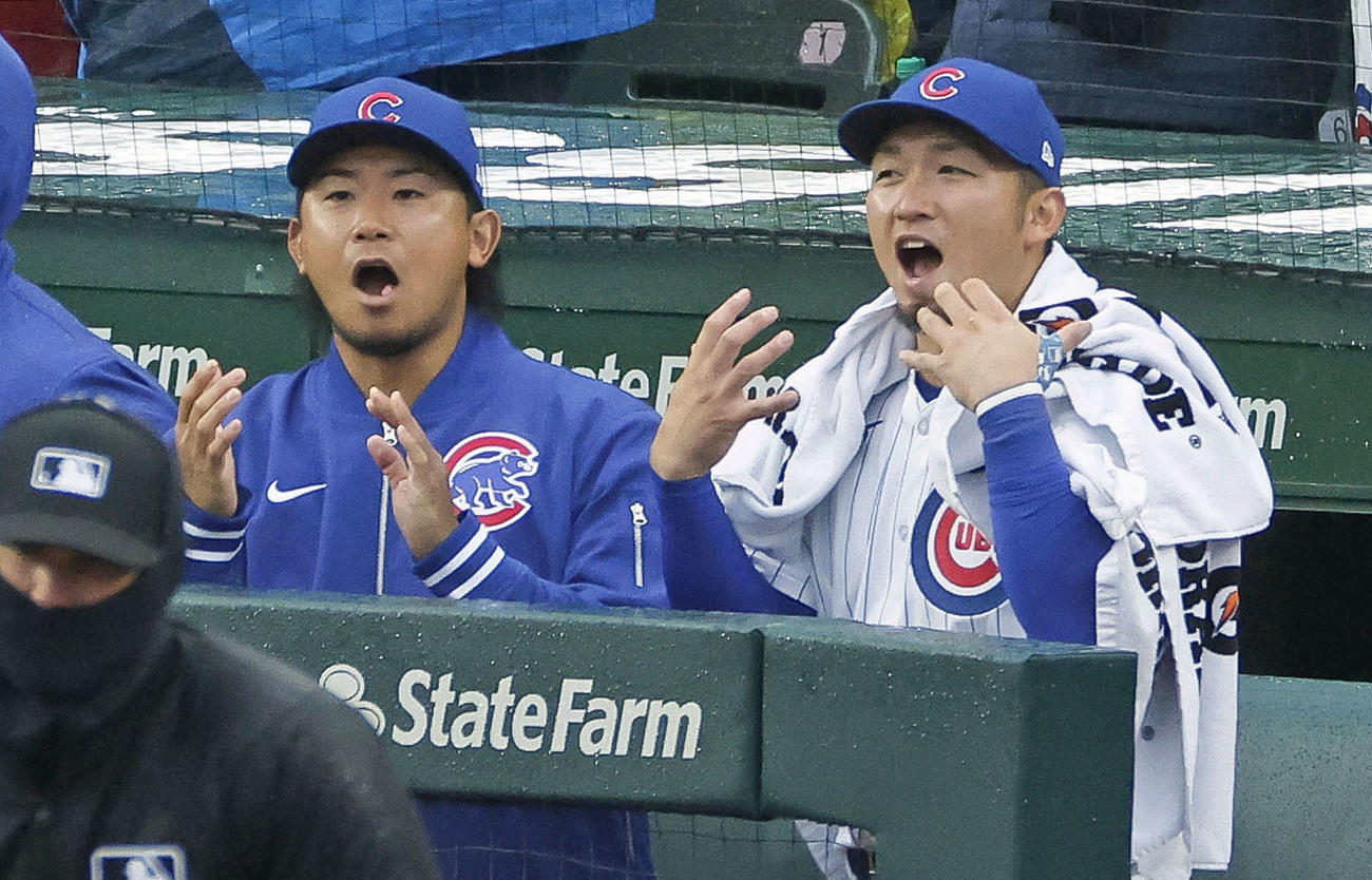 ロッキーズに勝利してベンチで喜ぶカブス今永（左）と鈴木（共同）