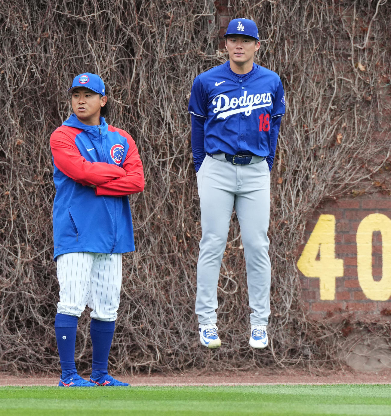 カブス対ドジャース　試合前、カブス今永（左）と話すドジャース山本は、あまりの寒さに飛び跳ねる（撮影・菅敏）