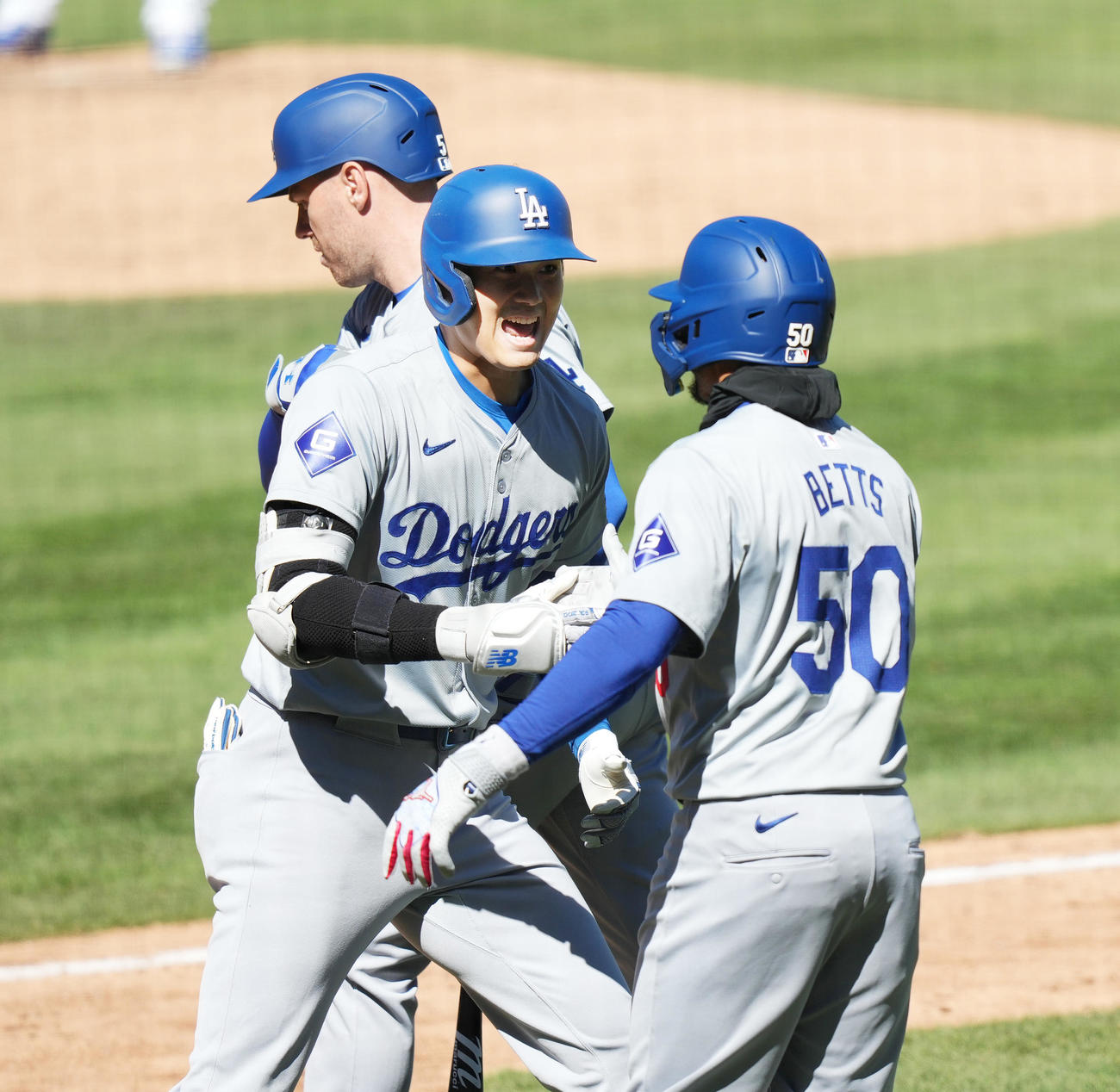 カブス対ドジャース　5回表ドジャース無死一塁、右越えに2号2点本塁打を放ち、フリーマン（左）、ベッツ（右）にタッチで迎えられる大谷（撮影・菅敏）