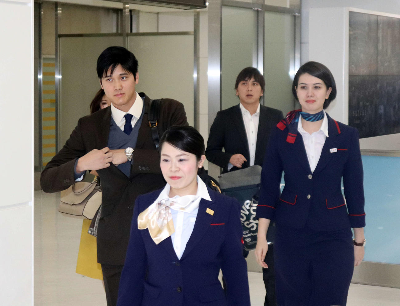 JAL職員にエスコートされながら帰国する大谷（左）。後方右は水原通訳（2018年11月21日撮影）