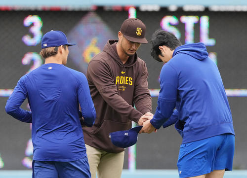 ドジャース対パドレス　試合前、パドレス・ダルビッシュ（中央）に握手であいさつするドジャース大谷と山本（左）（撮影・菅敏）