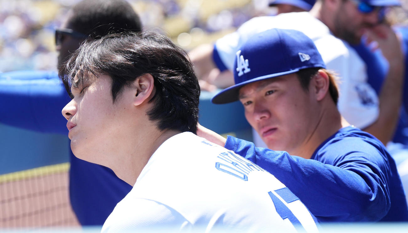 ドジャース対ナショナルズ　試合中、ベンチで大谷（手前）の頭に付着した何かを見つけ、取り除く山本（撮影・菅敏）