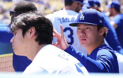 ドジャース対ナショナルズ　試合中、ベンチで大谷（手前）の頭に付着した何かを見つけ、取り除く山本（撮影・菅敏）