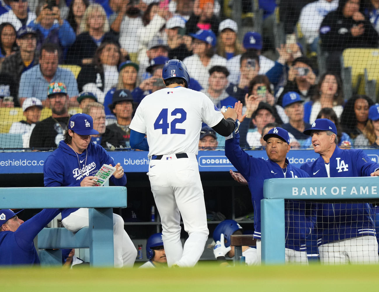 ドジャース対ナショナルズ　1回裏ドジャース1死一、三塁、スミスの犠飛で三塁から生還し、ロバーツ監督（右から2人目）に迎えられる大谷（撮影・菅敏）