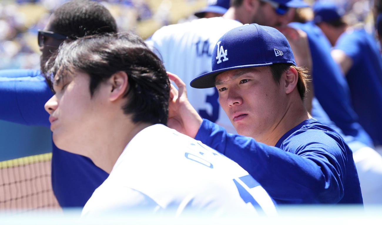 ドジャース対ナショナルズ　試合中、ベンチで大谷（手前）の頭に付着した何かを見つけ、取り除く山本（撮影・菅敏）