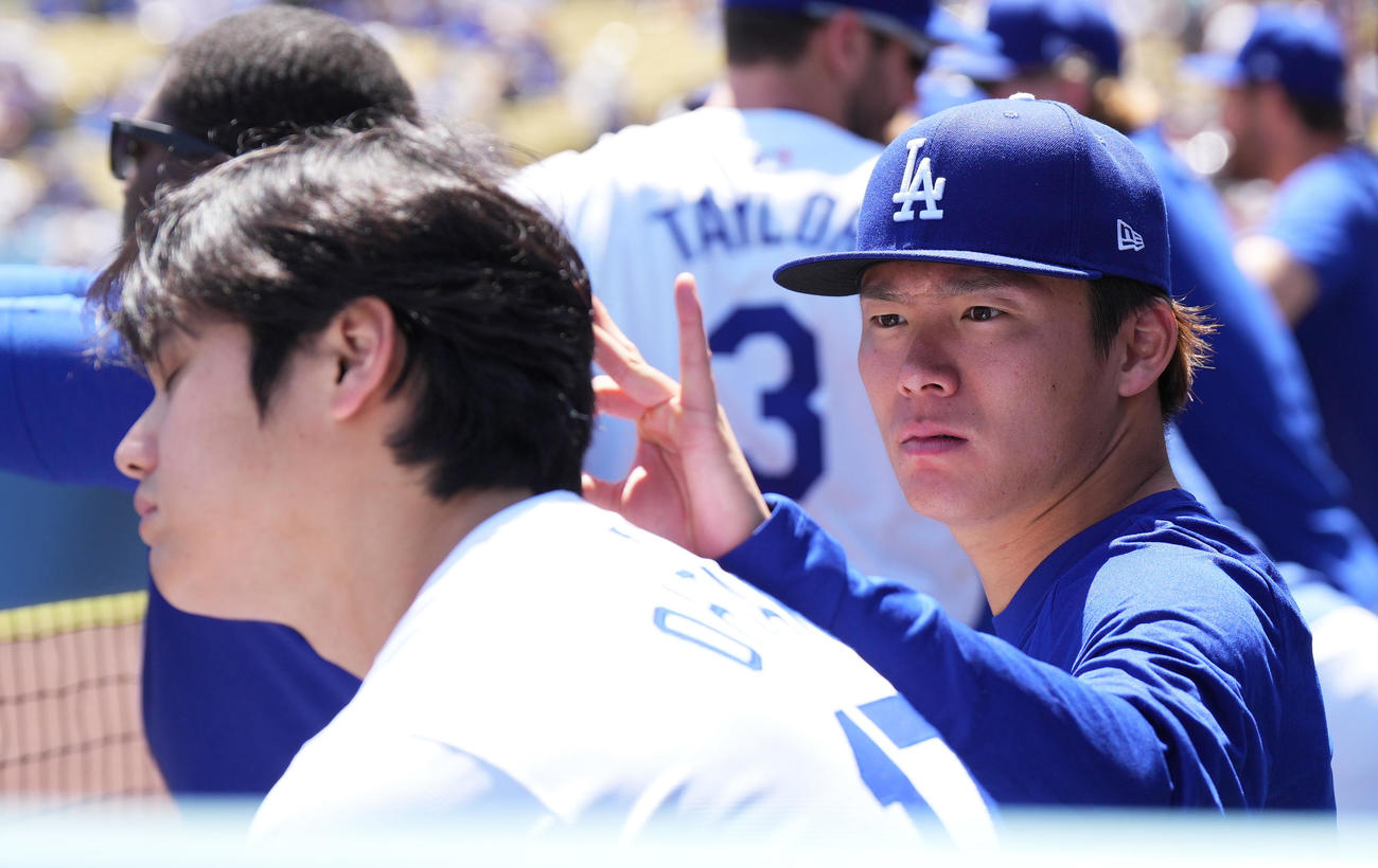 ドジャース対ナショナルズ　試合中、ベンチで大谷（手前）の頭に付着した何かを見つけ、取り除く山本（撮影・菅敏）