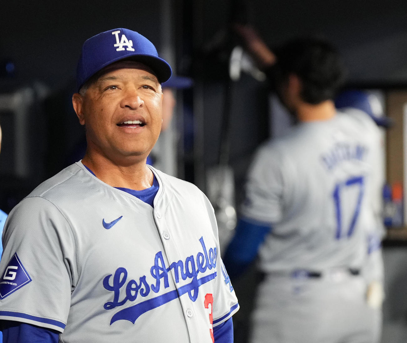 ブルージェイズ対ドジャース　試合前、ベンチで笑顔を見せるロバーツ監督。後方は大谷（撮影・菅敏）