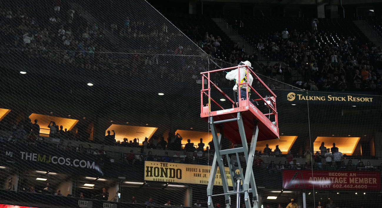 ダイヤモンドバックス対ドジャース　試合開始直前、バックネット上に群がるハチを駆除する係員（撮影・菅敏）