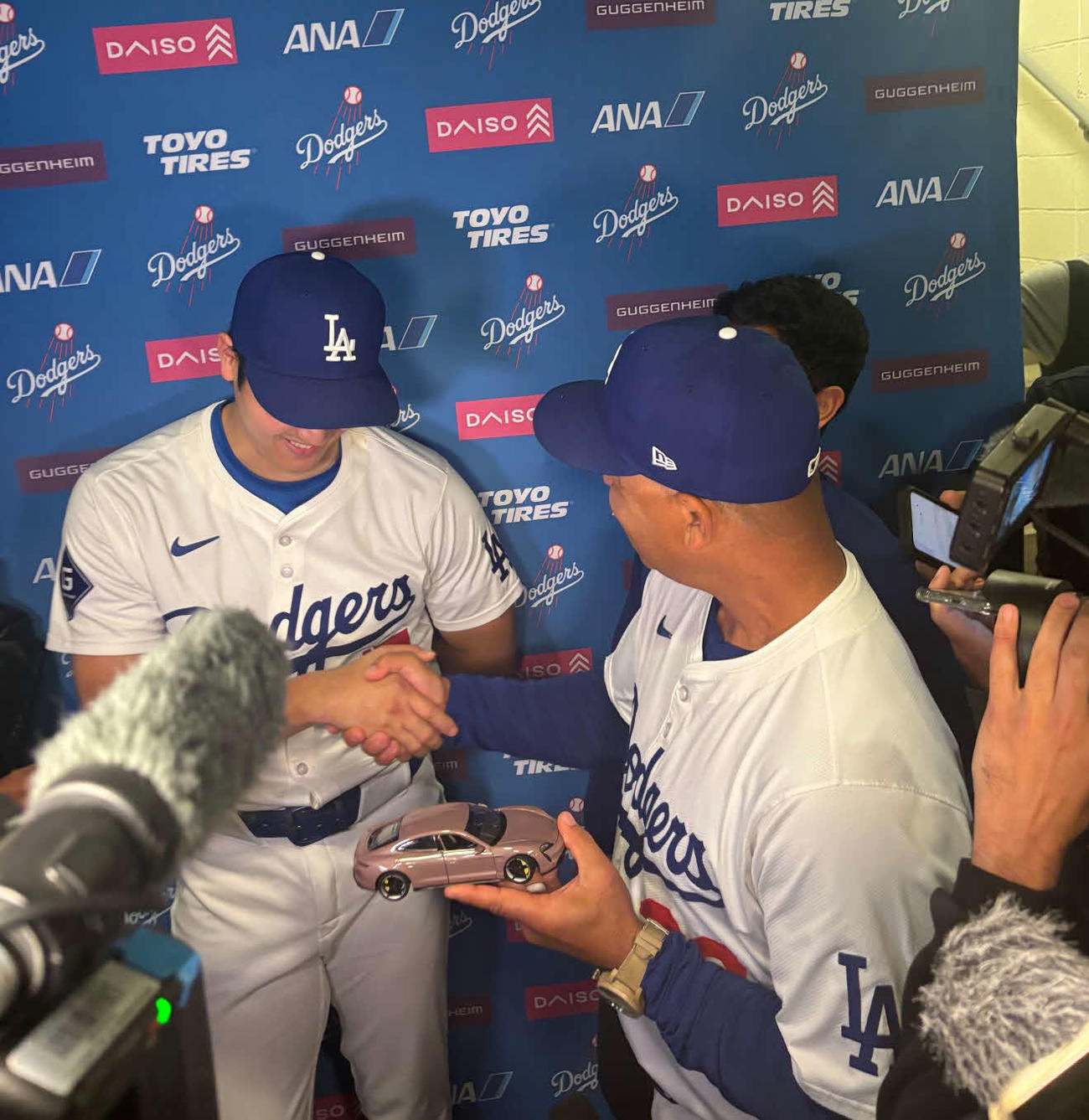 大谷の試合後の囲み会見に登場したデーブ・ロバーツ監督。ポルシェのおもちゃを手にし、握手をかわす（撮影・斎藤庸裕）