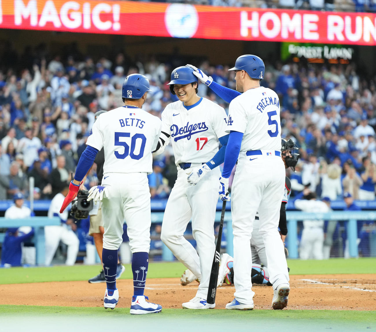 ドジャース対マーリンズ　1回裏ドジャース無死一塁、中越えに11号2点本塁打を放ち、ベッツ（左）、フリーマン（右）に迎えられ笑顔を見せる大谷（撮影・菅敏）