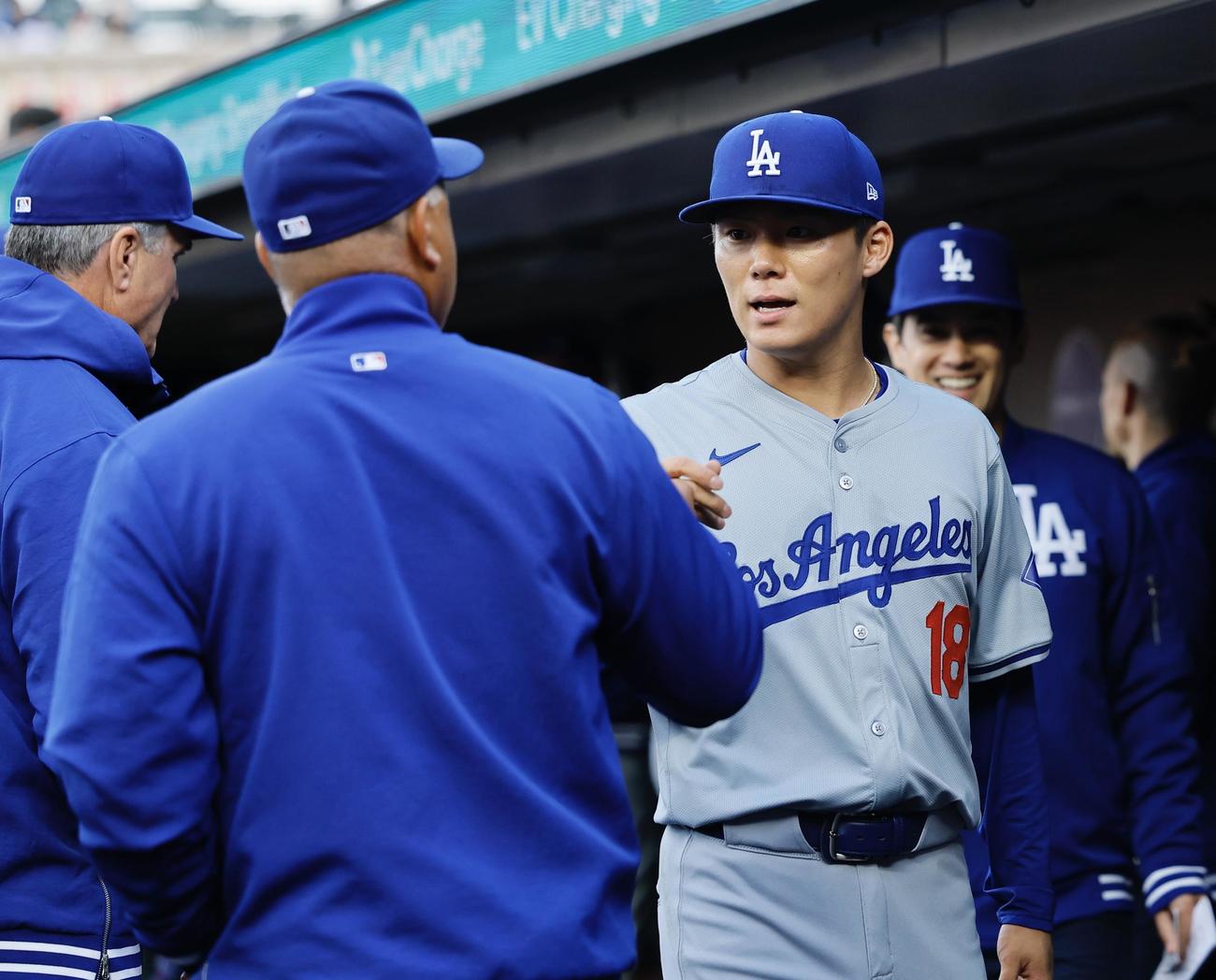 ジャイアンツ対ドジャース　試合前、ロバーツ監督（左）とタッチを交わす山本（撮影・藤尾明華）
