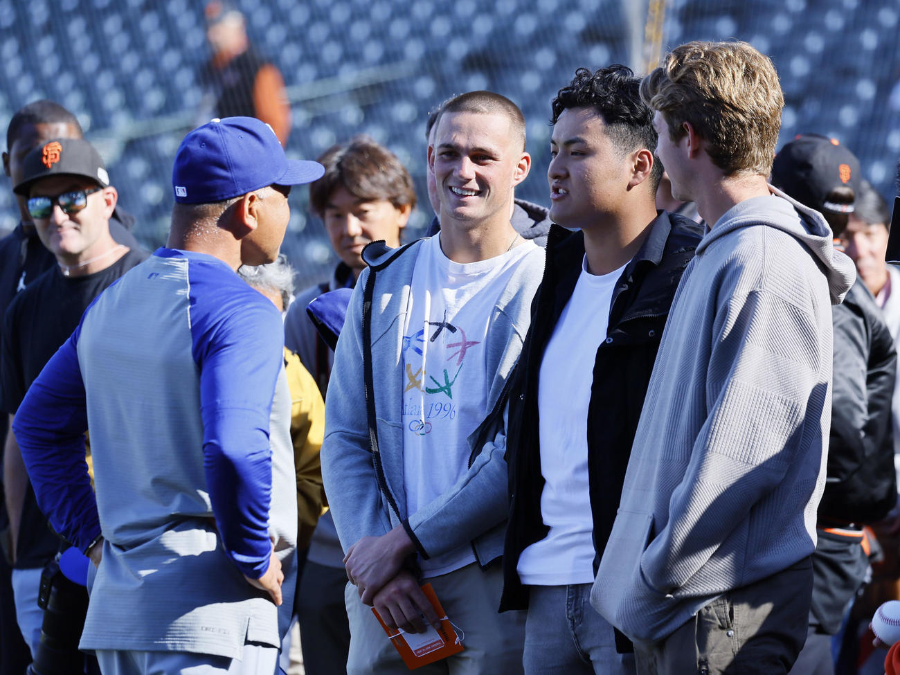 ジャイアンツ対ドジャース　球場を訪れ、ドジャースのロバーツ監督（右）と握手を交わすスタンフォード大学に進学した佐々木麟太郎（左から2人目）（撮影・藤尾明華）