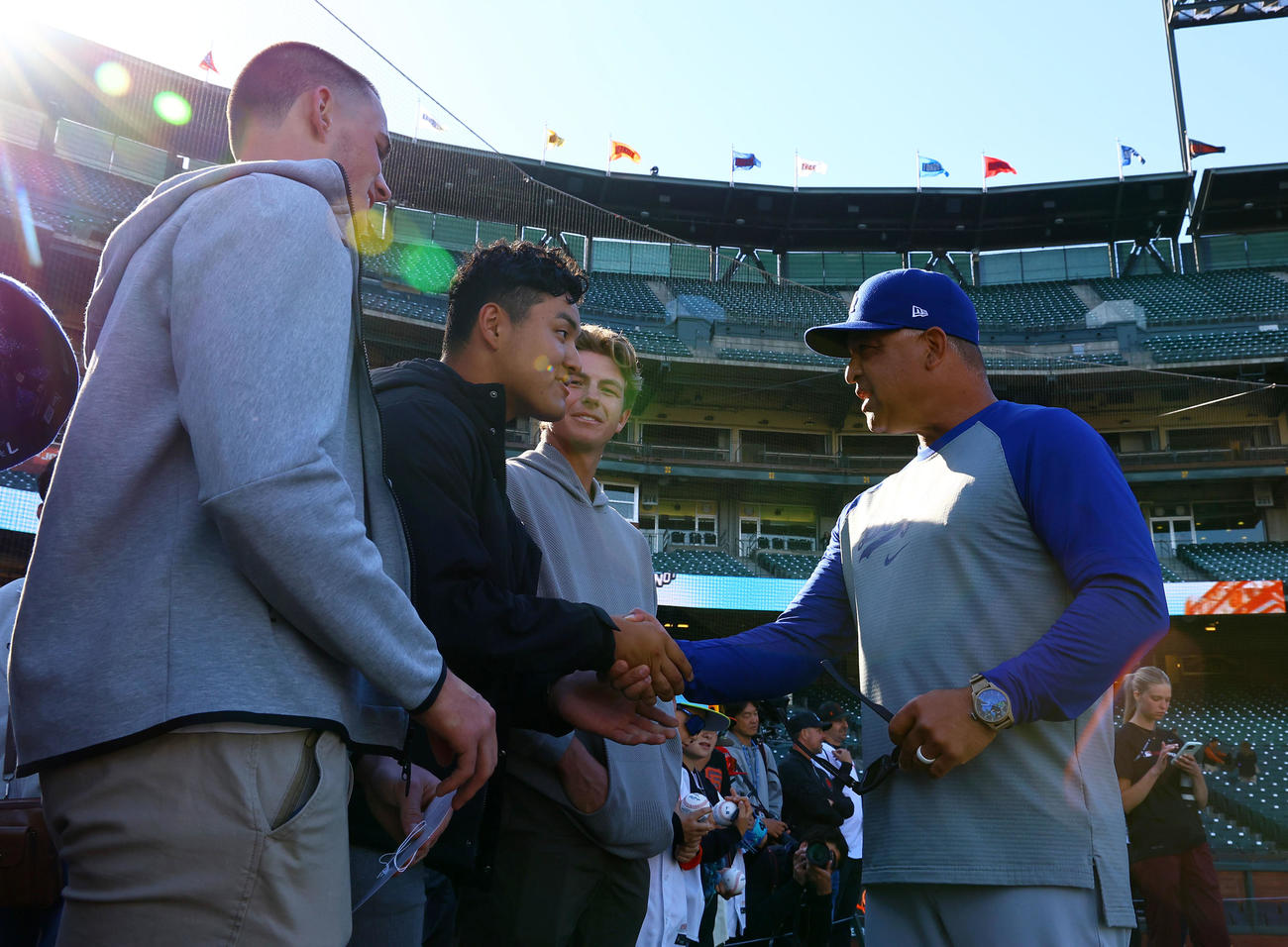 ジャイアンツ対ドジャース　球場を訪れ、ドジャースのロバーツ監督（右）と握手を交わすスタンフォード大学に進学した佐々木麟太郎（左から2人目）（撮影・藤尾明華）