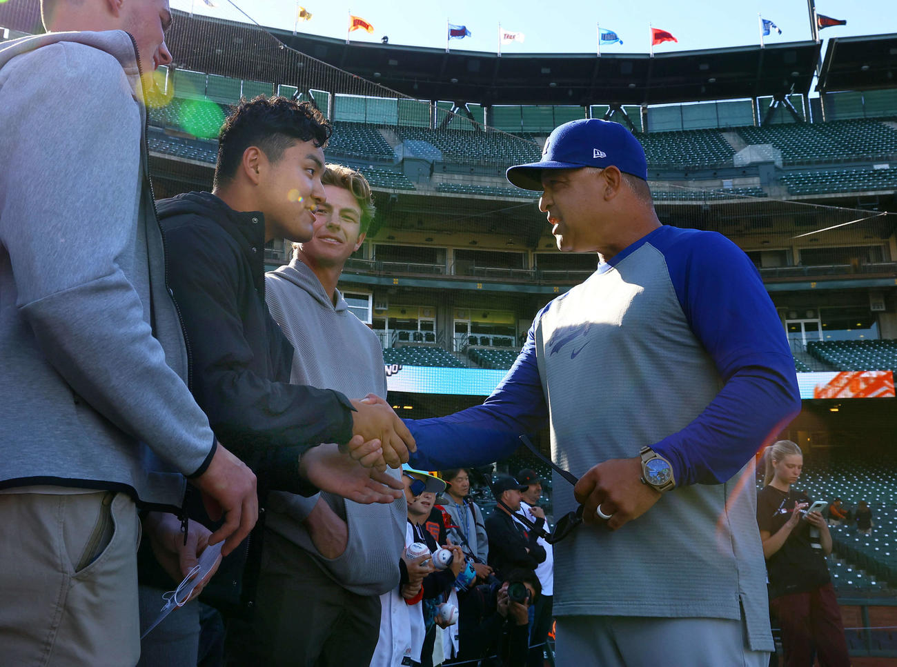 ジャイアンツ対ドジャース　球場を訪れ、ドジャースのロバーツ監督（右）と握手を交わすスタンフォード大学に進学した佐々木（撮影・藤尾明華）