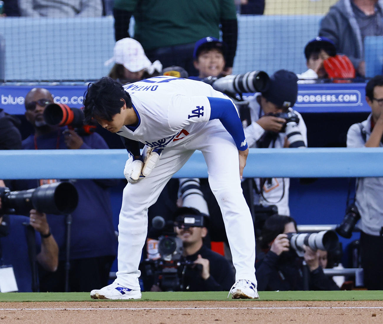 ドジャース対レッズ　1回裏ドジャース2死一塁、けん制球が左足に当たり、投手交代の合間に足を伸ばす大谷（撮影・藤尾明華）