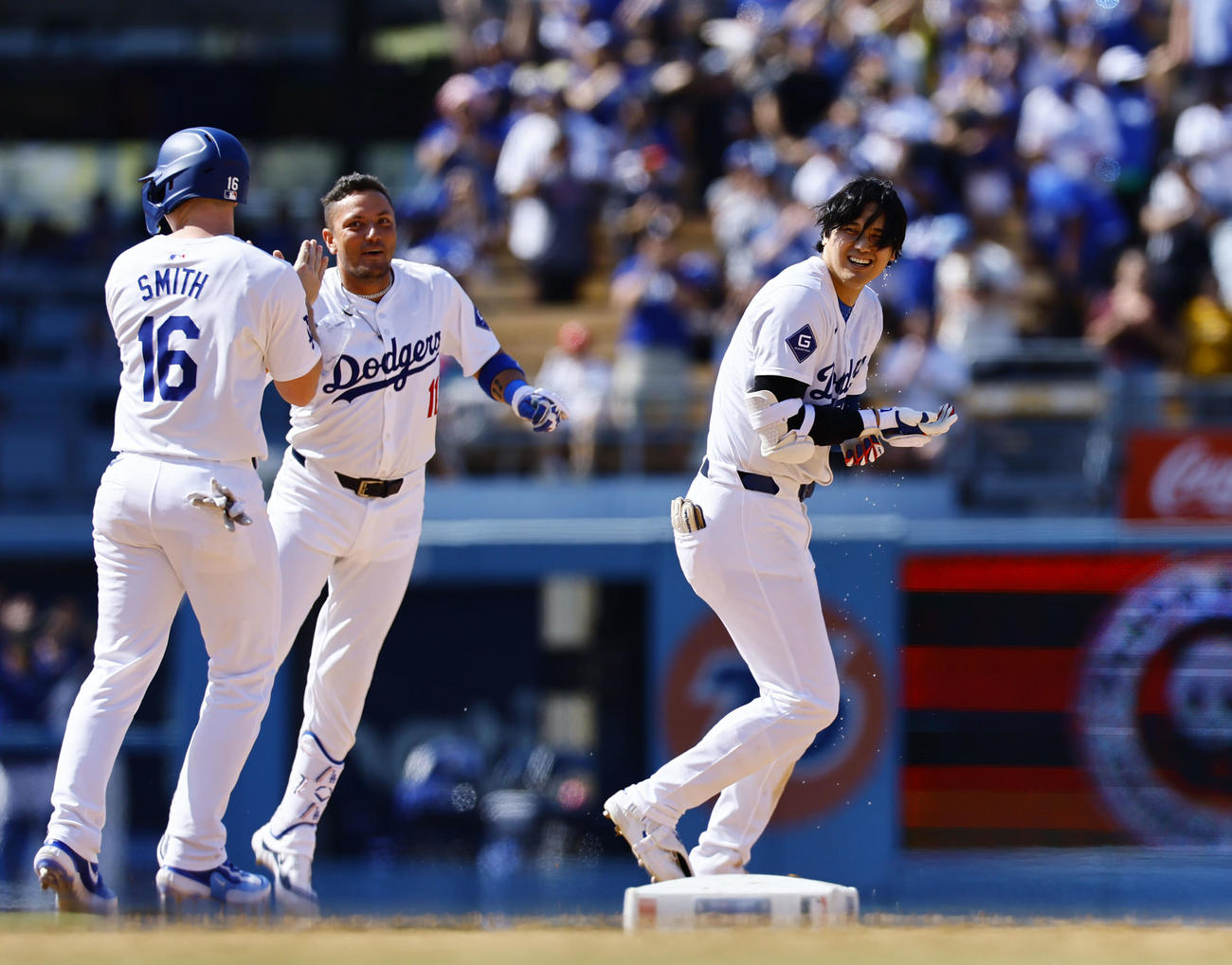 ドジャース対レッズ　10回裏ドジャース2死一、二塁、サヨナラ打を放ち、祝福され笑顔を見せる大谷（右）（撮影・藤尾明華）