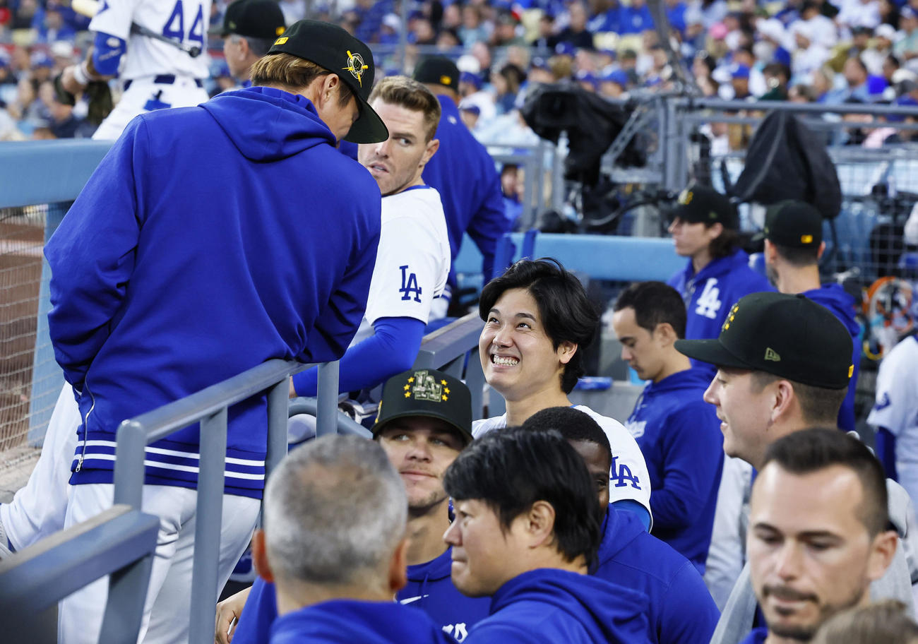 ドジャース対レッズ　6回、ベンチで山本（左端）と談笑すドジャース大谷（中央）（撮影・藤尾明華）
