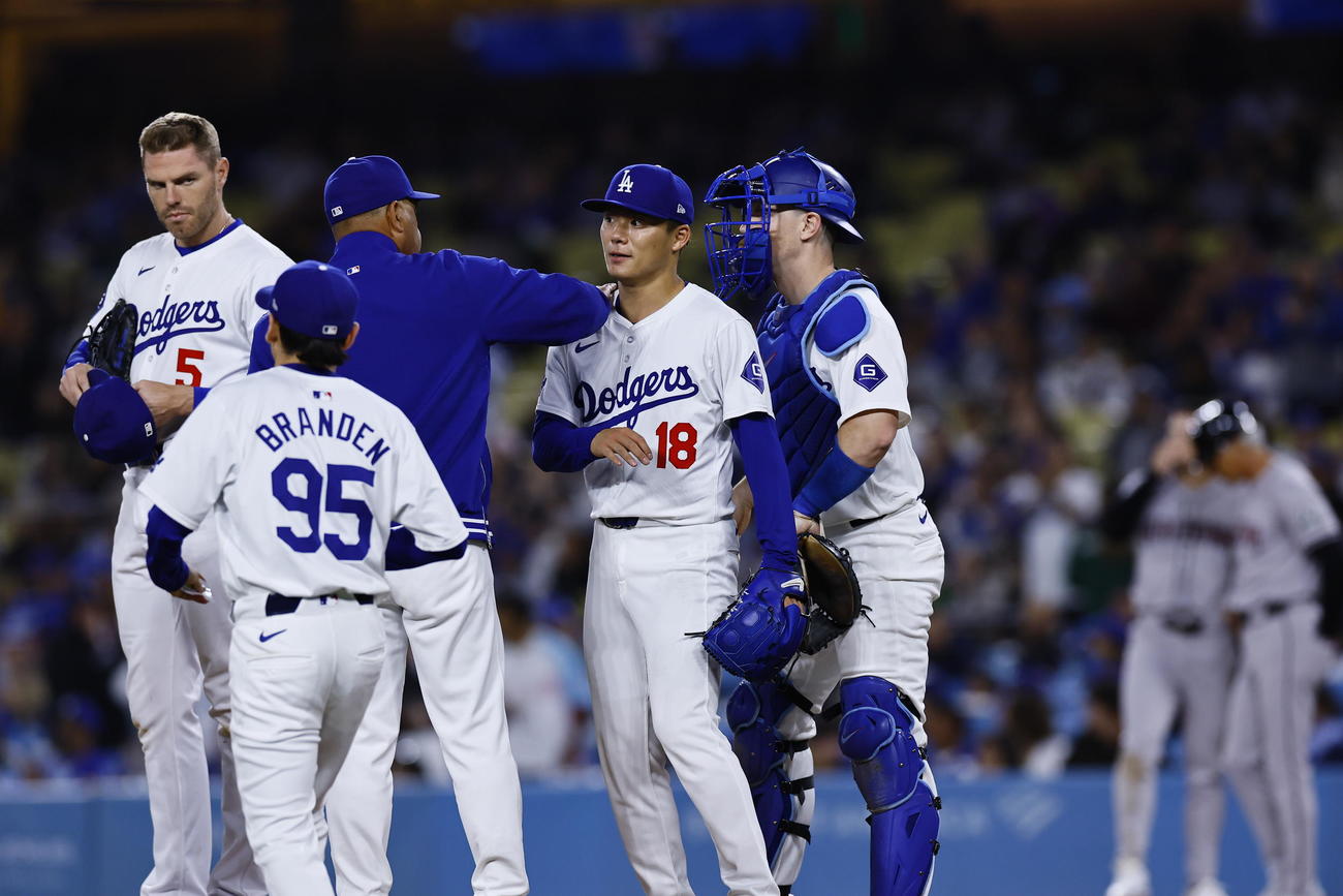 ドジャース対ダイヤモンドバックス　7回途中、ロバーツ監督に肩をたたかれ降板するドジャース山本（右から2人目）（撮影・藤尾明華）