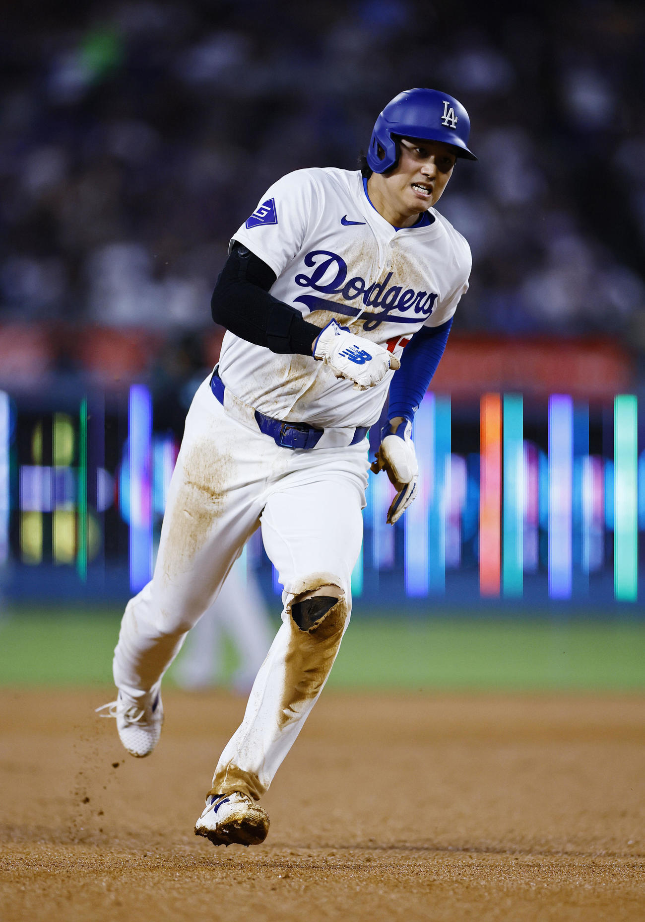 ドジャース対ダイヤモンドバックス　6回裏ドジャース1死二塁、スミスの中前適時打で二塁から生還する大谷。ユニホームの左膝がスライディングした影響でビリビリ（撮影・藤尾明華）