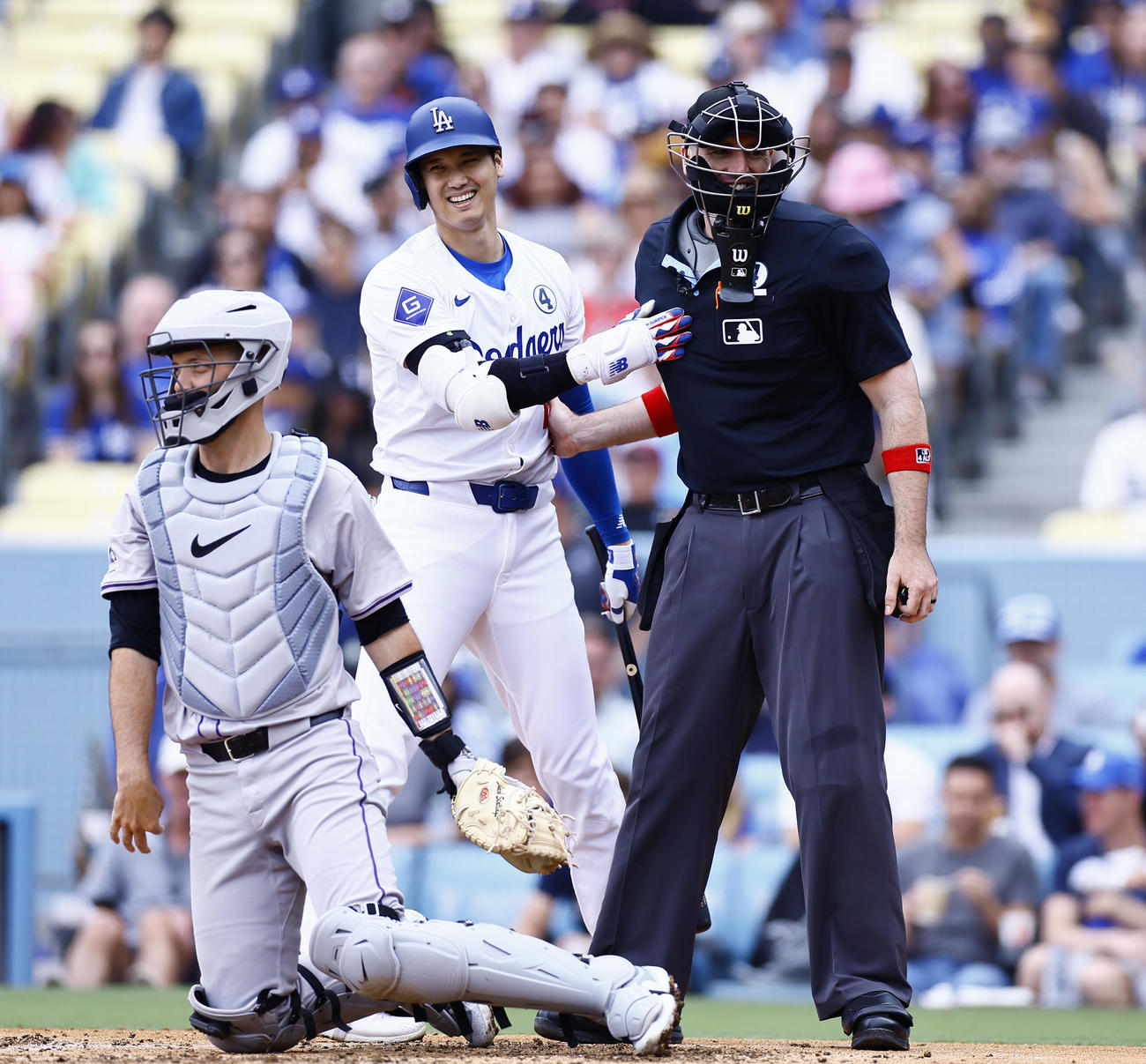 ドジャース対ロッキーズ　4回裏ドジャース1死一塁、ファウルの打球が2度も当たった主審と言葉を交わし、笑顔を見せる大谷（撮影・藤尾明華）