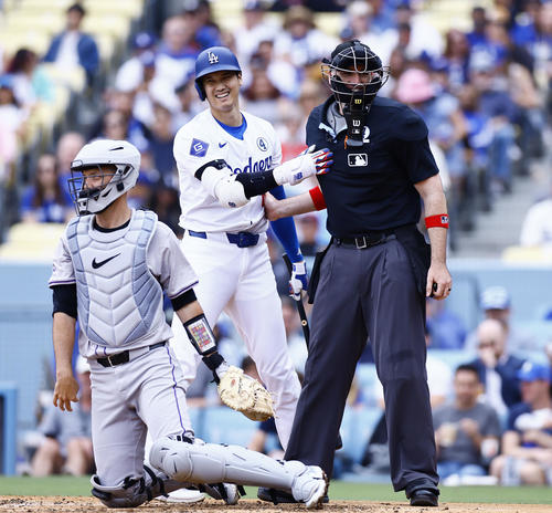 ドジャース対ロッキーズ　4回裏ドジャース1死一塁、ファウルの打球が2度も当たった主審と言葉を交わし、笑顔を見せる大谷（撮影・藤尾明華）