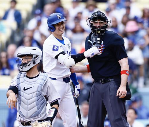ドジャース対ロッキーズ　4回裏ドジャース1死一塁、ファウルの打球が当たった主審と言葉を交わし、笑顔を見せる大谷翔平（中央）（撮影・藤尾明華）