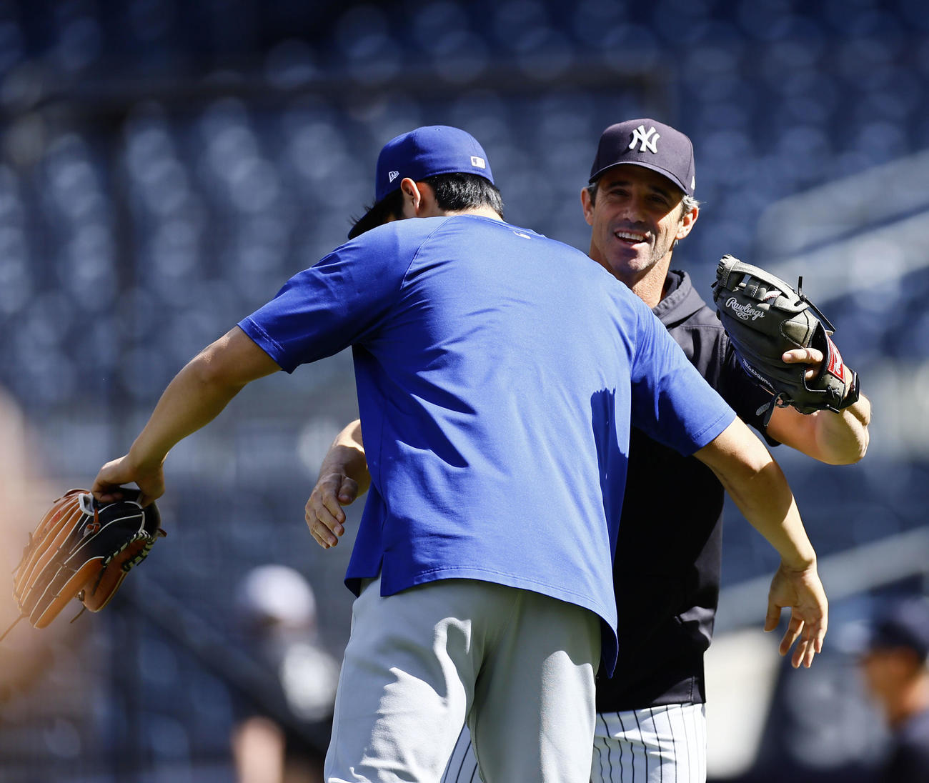 ヤンキース対ドジャース　抱き合ってあいさつするヤンキースのオースマスコーチ（右）とドジャース大谷（撮影・藤尾明華）