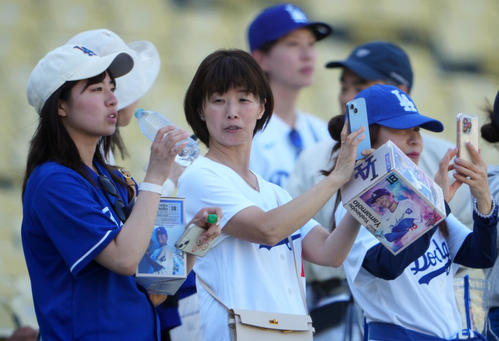 ドジャース対レンジャーズ　入場の際に配られたドジャース山本のボブルヘッドを手にするファン（撮影・横山健太）