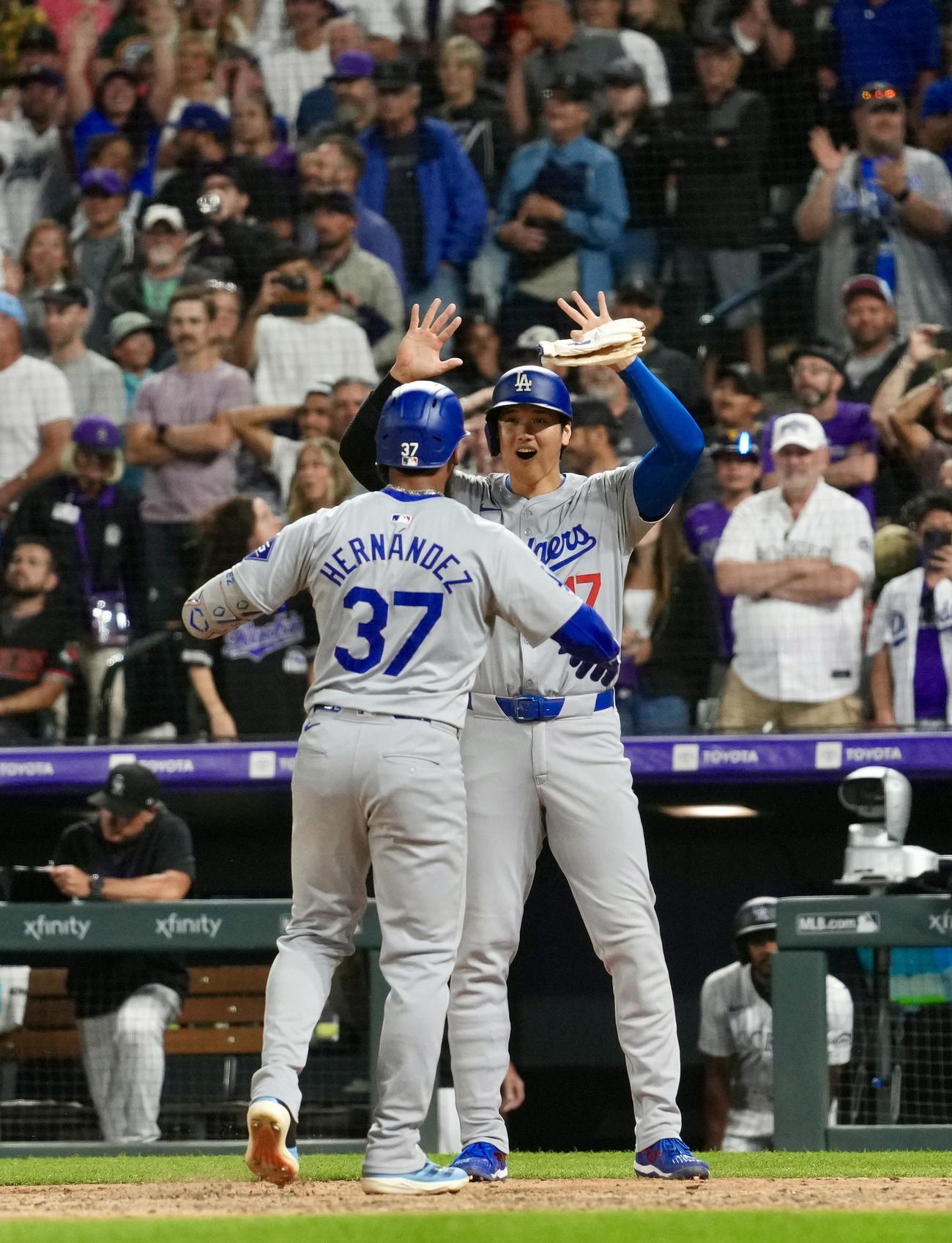 ロッキーズ対ドジャース　9回表ドジャース2死一、二塁、中越え3点本塁打を放ったT．ヘルナンデスをタッチで迎える大谷（撮影・横山健太）