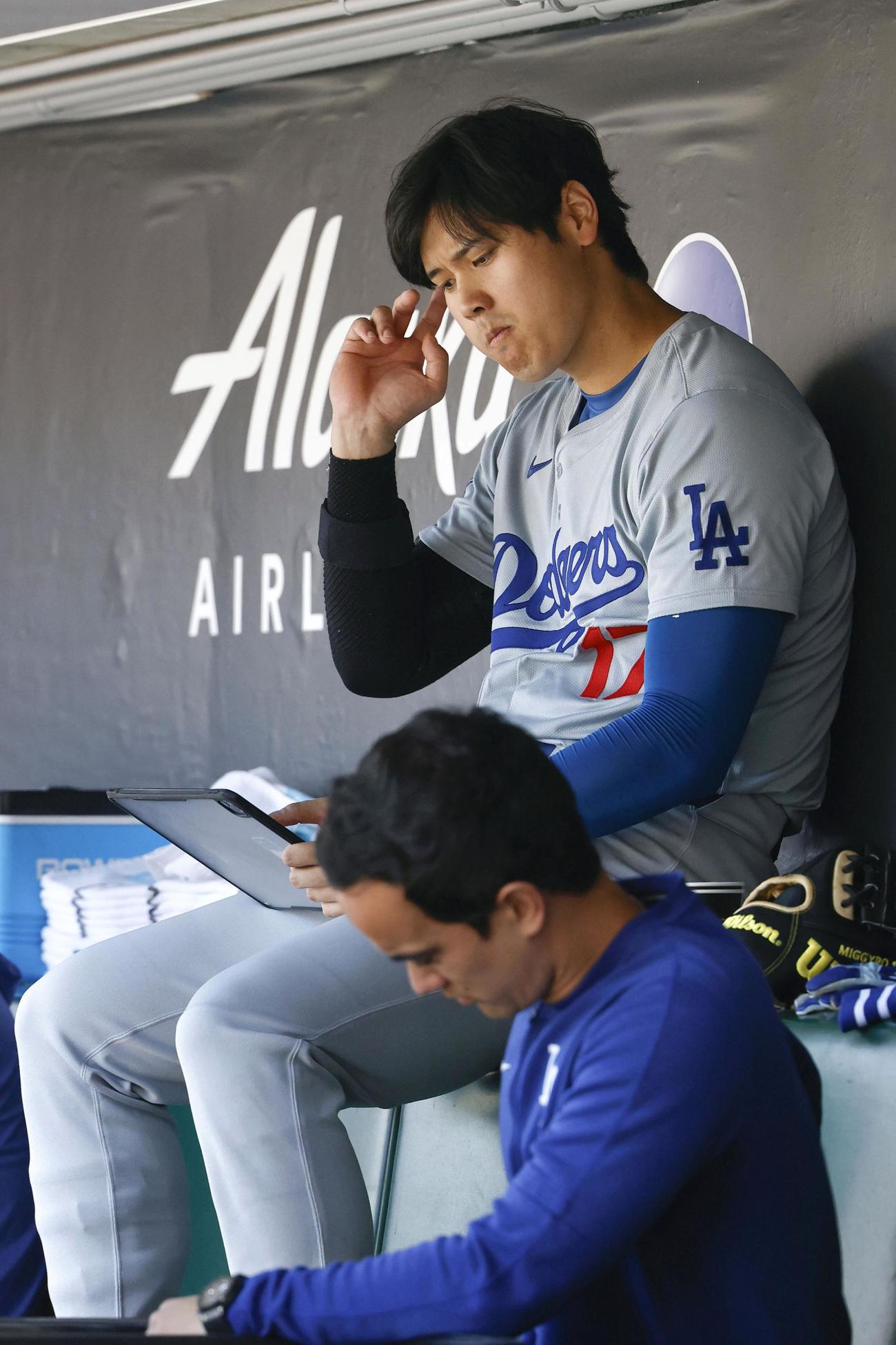 ジャイアンツ戦の5回、空振り三振に倒れ、ベンチでタブレット端末を見るドジャース・大谷＝サンフランシスコ（共同）