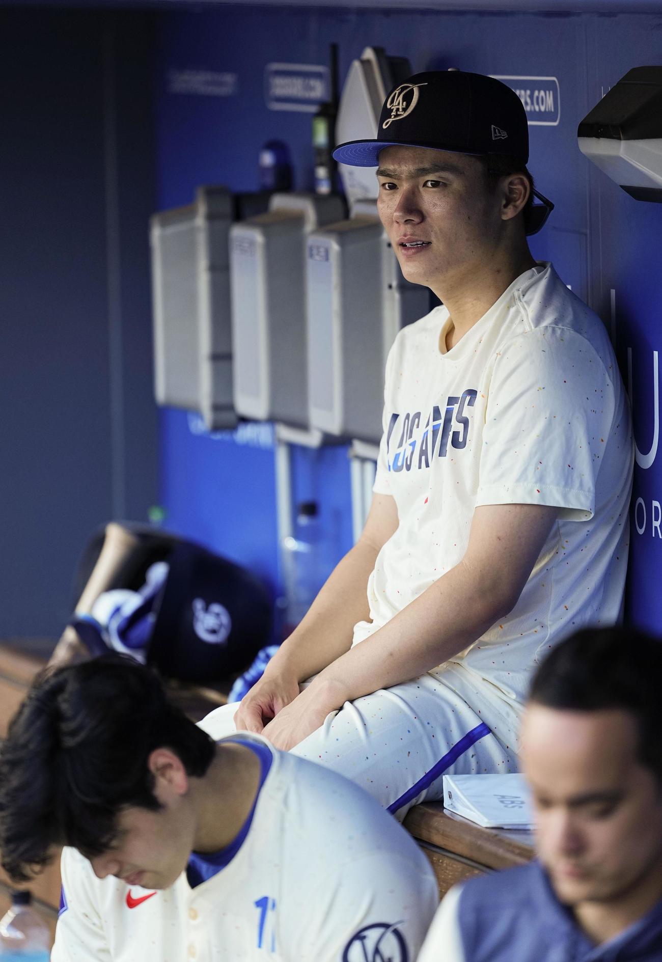 ブルワーズ戦でベンチに座る山本由伸。左下は大谷翔平（共同）