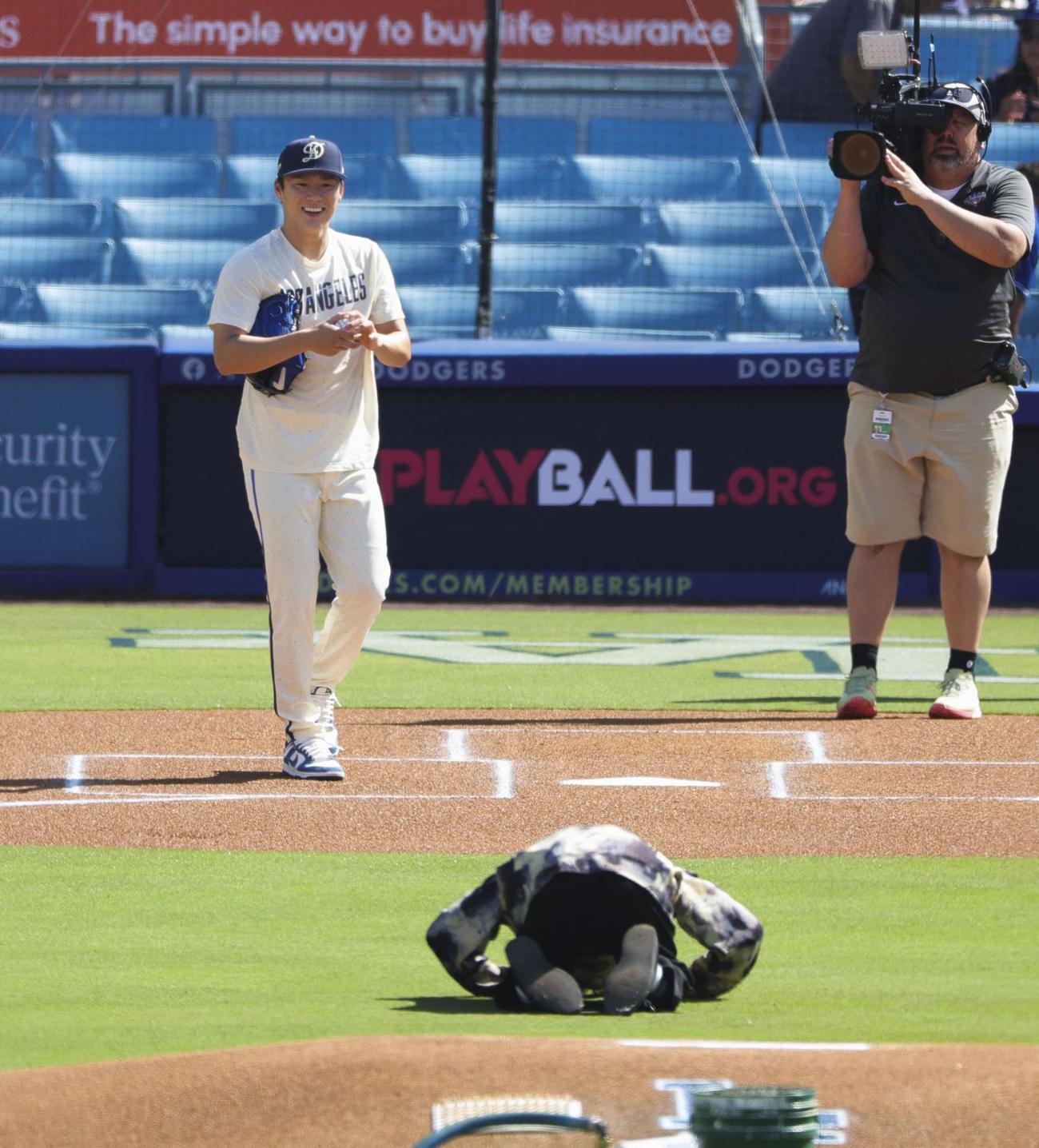 始球式がバウンドする投球となり、土下座するDJ松永（手前）。奥左は笑顔を見せる捕手役のドジャース山本（共同）