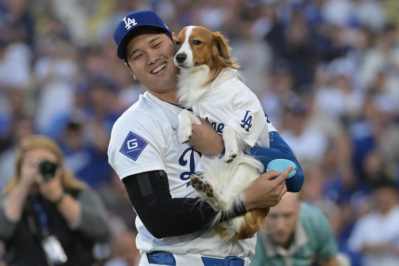 ドジャース対オリオールズ　始球式を終えた愛犬デコピンを抱える大谷（USA TODAY Sports＝ロイター）