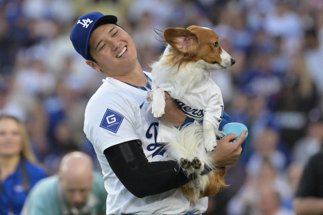 ドジャース対オリオールズ　始球式を終えた愛犬デコピンを抱える大谷（USA TODAY Sports＝ロイター）