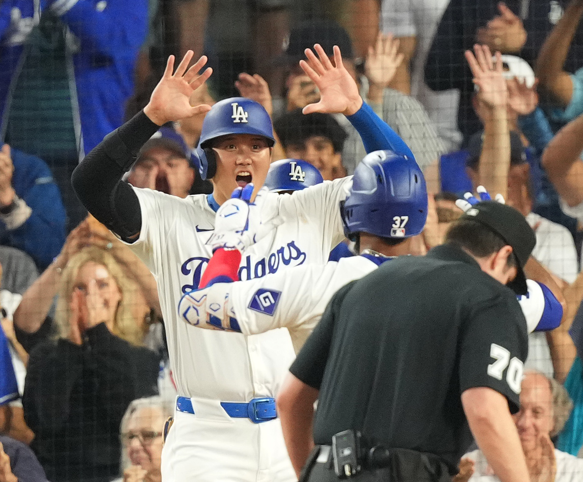 ドジャース対オリオールズ　3回裏ドジャース2死二、三塁、3点本塁打を放ったT・ヘルナンデス（手前）をタッチで迎える三塁走者大谷（撮影・菅敏）