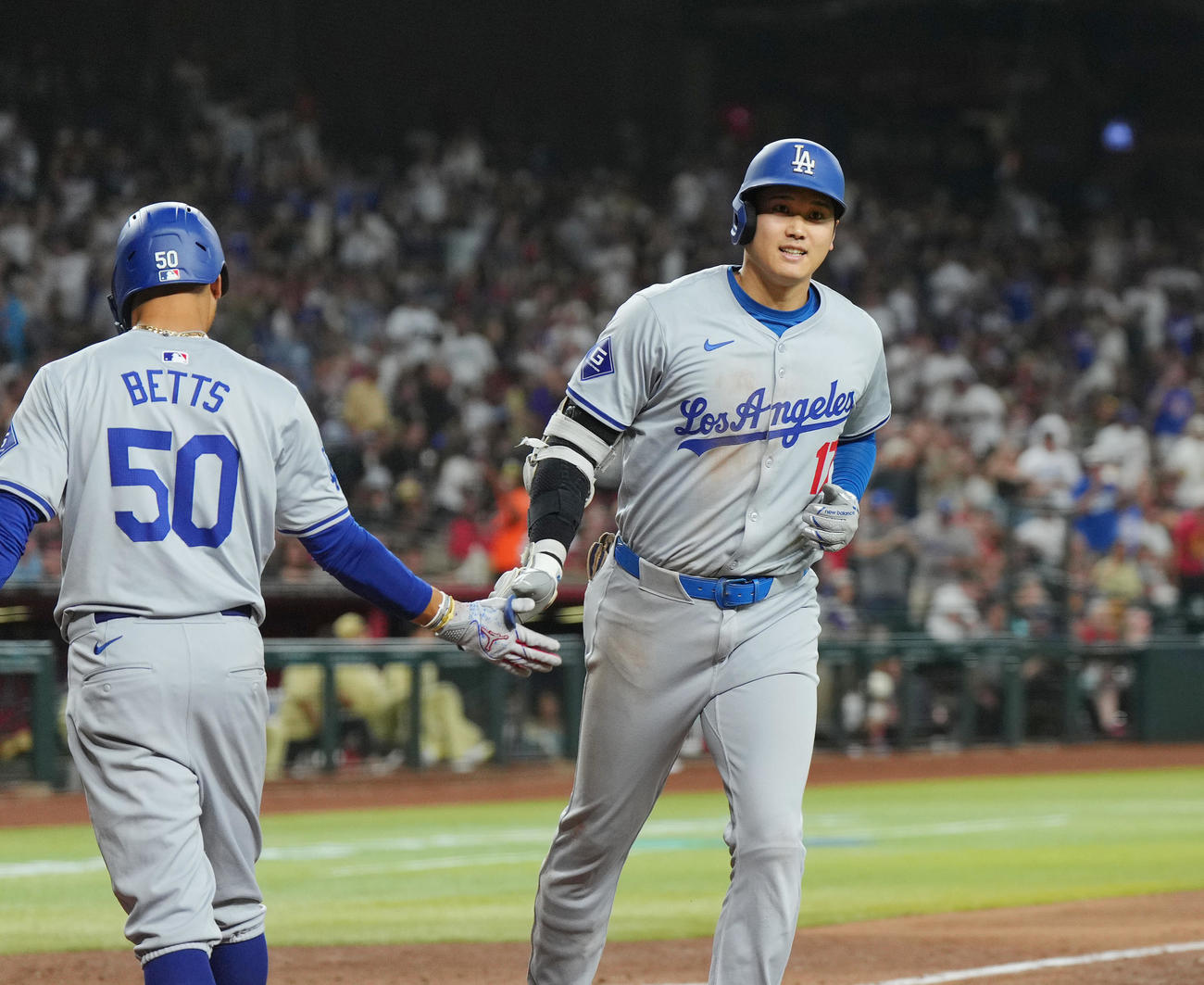 ダイヤモンドバックス対ドジャース　8回表ドジャース2死、左越えに43号ソロ本塁打を放ち、ベッツ（左）に迎えられる大谷（撮影・菅敏）
