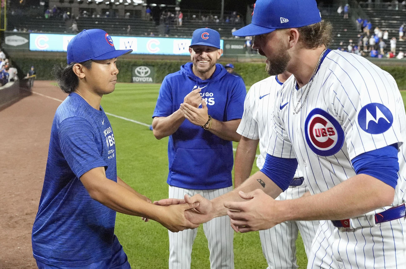 3投手の継投で無安打無得点試合を達成し、3番手ホッジ（右）と握手するカブス先発の今永＝シカゴ（AP＝共同）