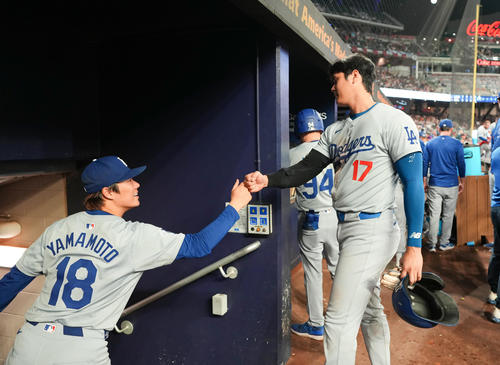 ブレーブス対ドジャース　5回の打席を終えベンチに戻った大谷は、登板を終えた山本（左）とタッチをする（撮影・菅敏）