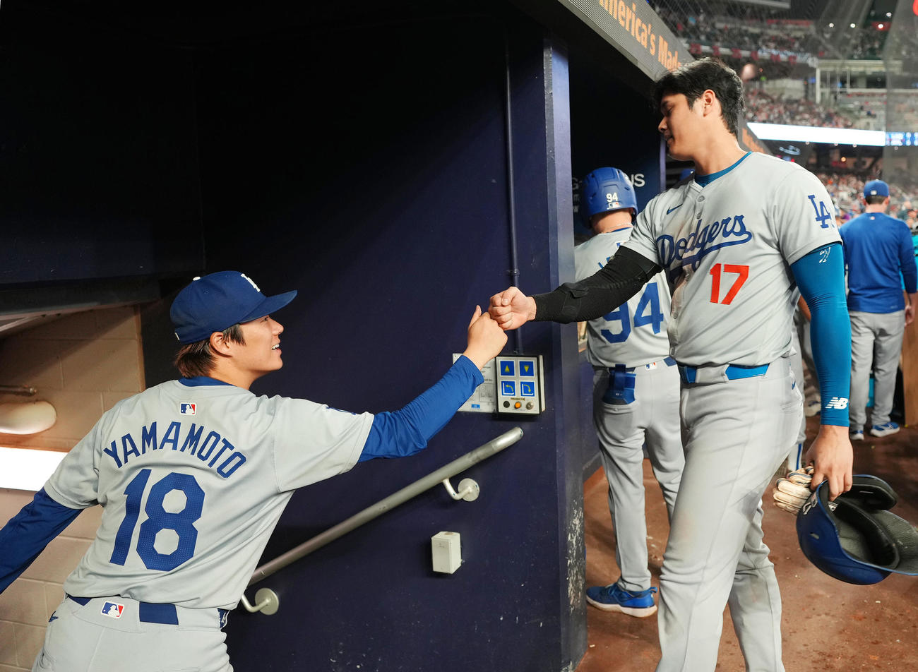 ブレーブス対ドジャース　4回を無失点に抑えた山本は、5回の打席を終えた大谷（右）にタッチで祝福される（撮影・菅敏）