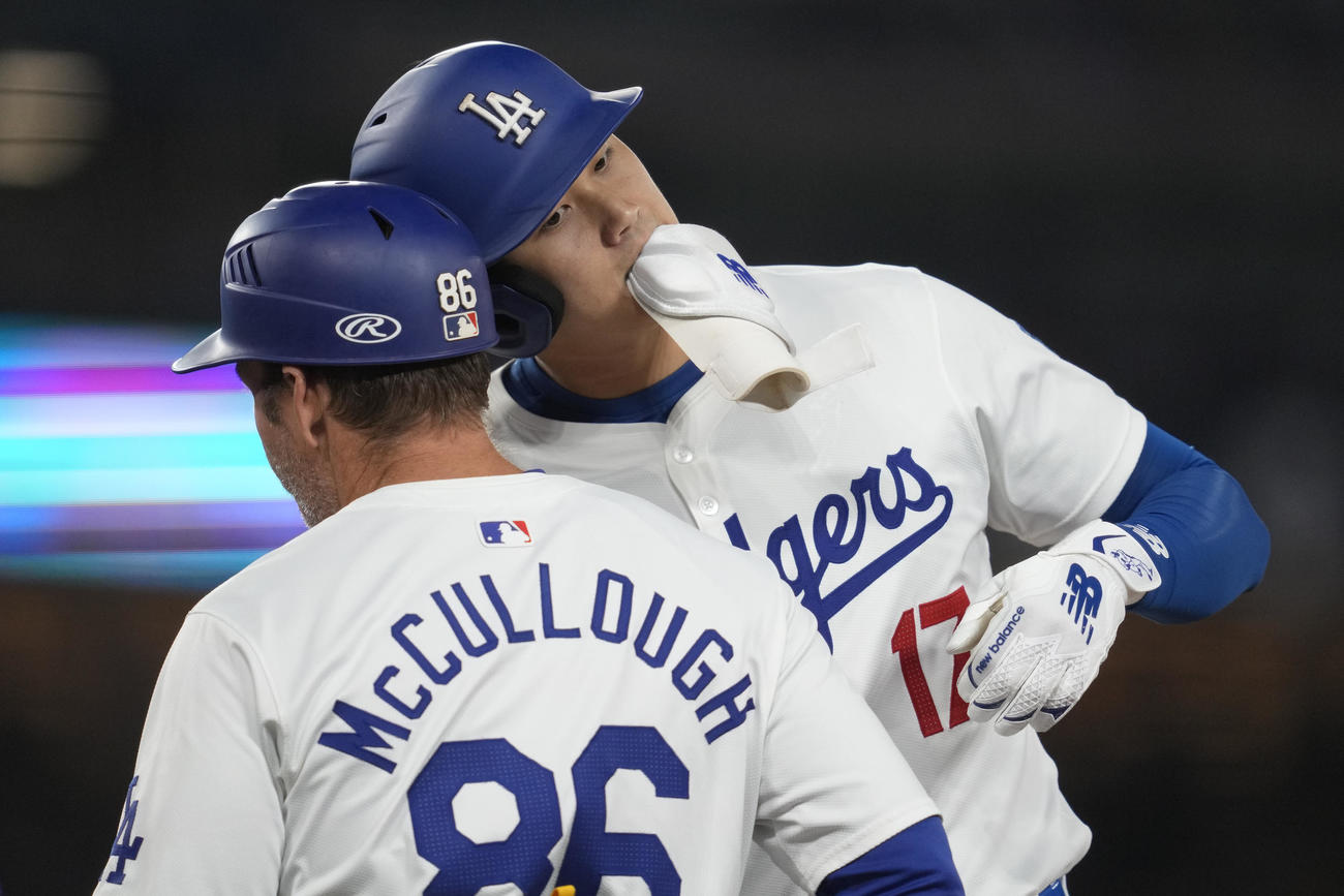 ドジャース大谷翔平がロッキーズ戦の3回に安打を打った後、一塁コーチと喜びを分かち合った。（AP）