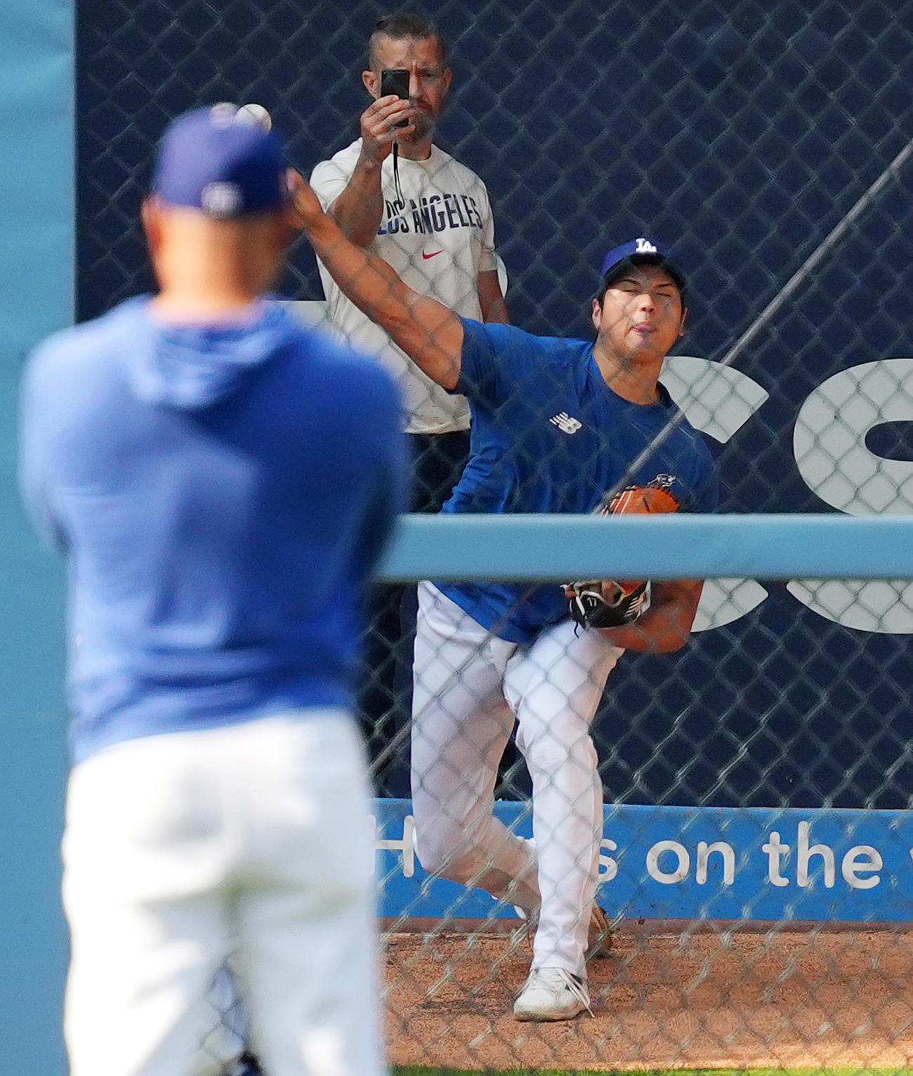 ドジャース対ロッキーズ　試合前、視線を送るロバーツ監督（手前）を前にブルペンで投球練習をするドジャース大谷（撮影・菅敏）